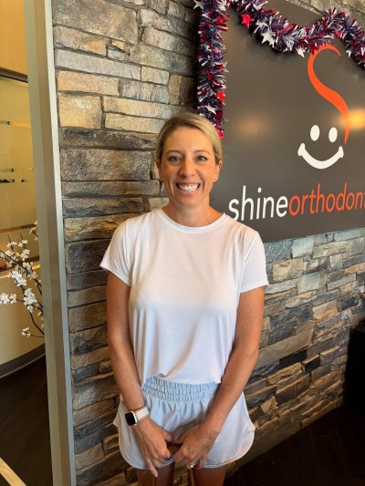 woman smiles with clear braces
